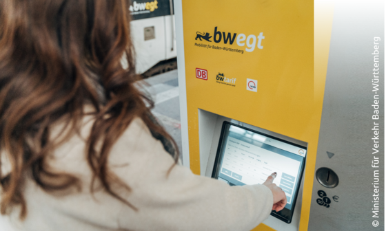 Frau steht an bwegt-Fahrkartenauomat und klickt durchs Menü