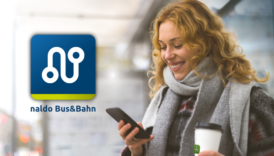 Frau schaut auf Handy und hat Tee-Becher in der Hand